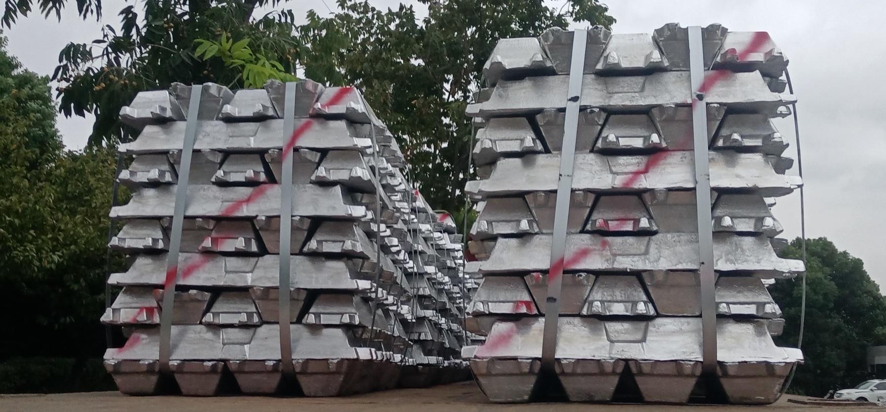 Strapped stacks of aluminium ingots, paint-marked for batch identification.