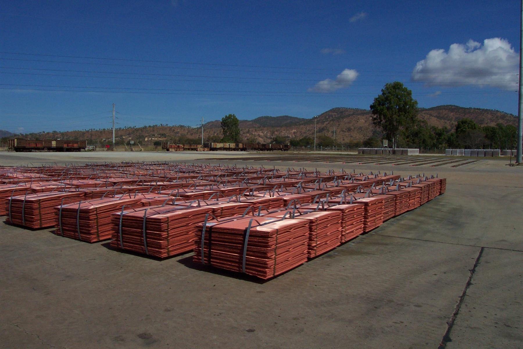 Banded bundles of copper cathode standing in rows in a refinery yard.